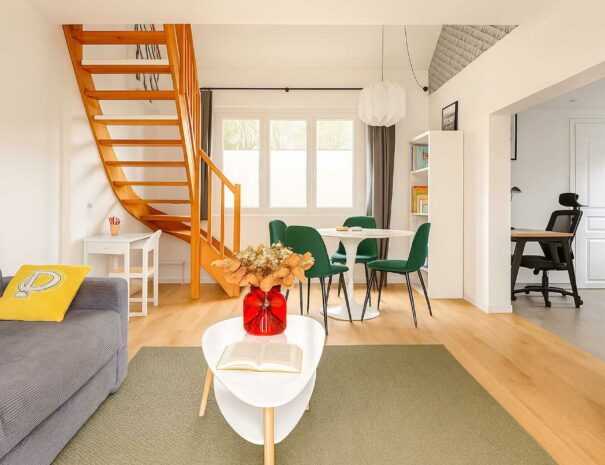Salon lumineux et cosy de Maison Mayel à Lamorlaye, avec coin repas, bibliothèque, espace bureau et canapé confortable – location touristique proche de Chantilly